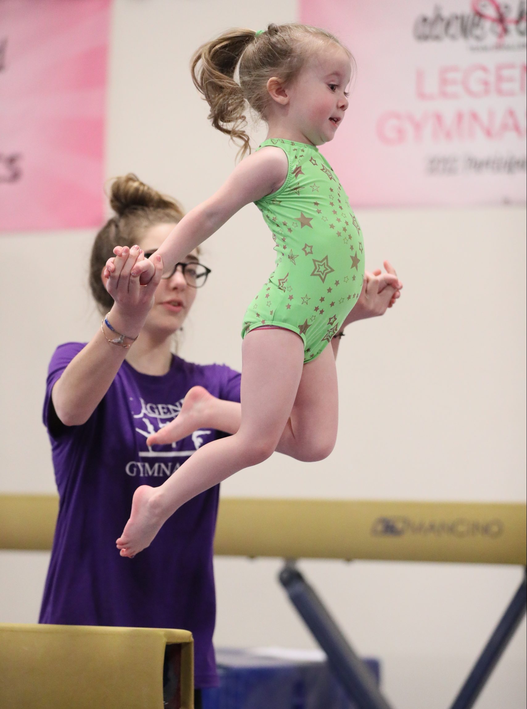 Girl jumping off beam at Legends Gymnastics in North Andover, MA.